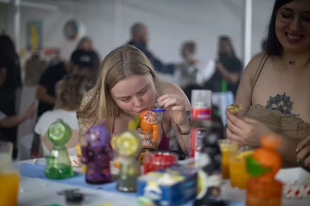 woman takes hash dab at cannabis event