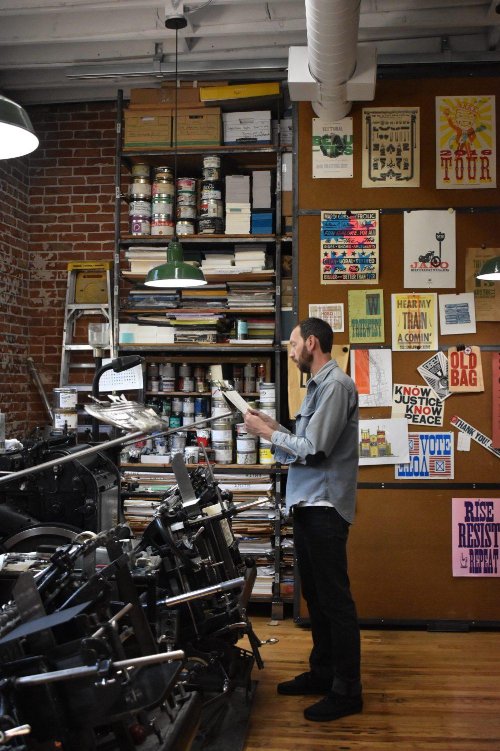 A man inspects prints