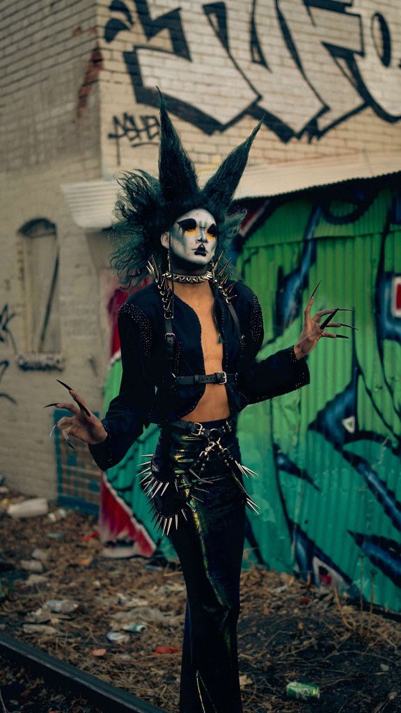 A drag performer in a spiky black outfit