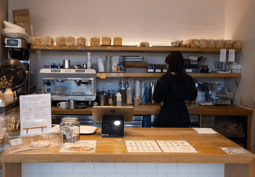 person behind counter of a coffee shop