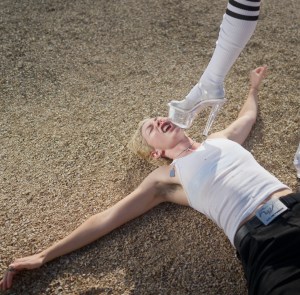 Denver musician Kitty Crimes lies on the ground as a high-heeled boot comes down to her face.