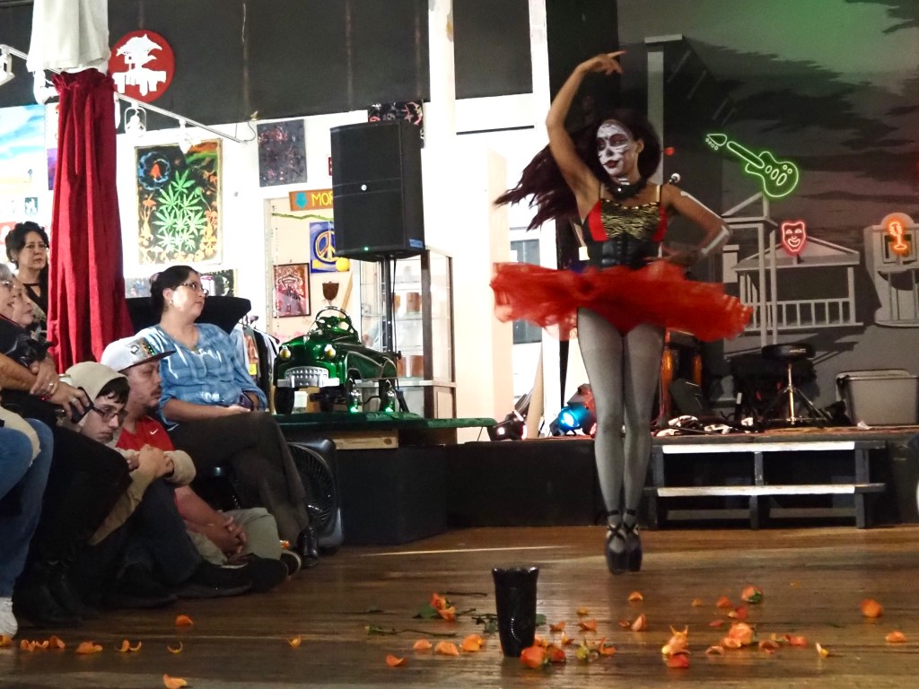 A dancer in a red tutu and black pointe shoes