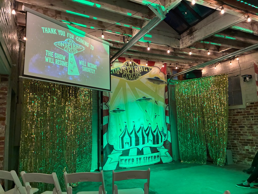 A stage with a sign reading "Conspiracy Circus."