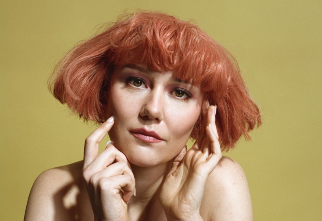 Molly Tuttle wearing a short auburn wig
