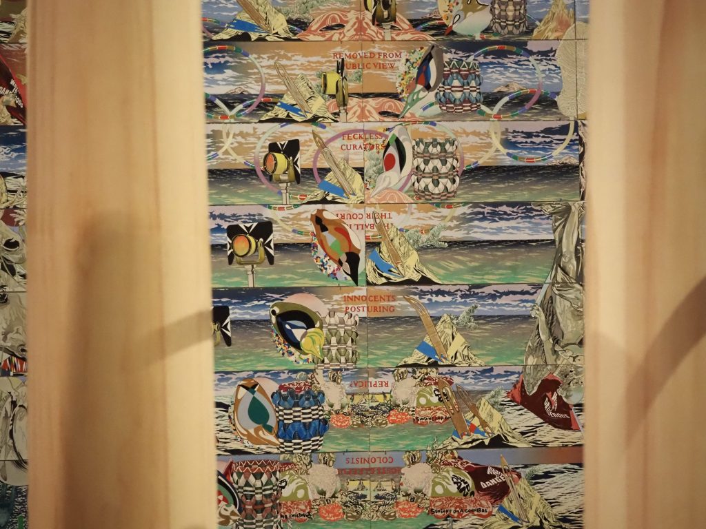 a colorful artwork behind pieces of wood