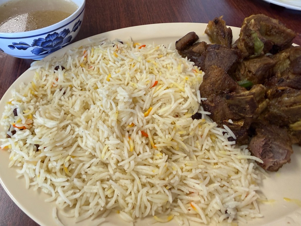 a plate of rice with goat