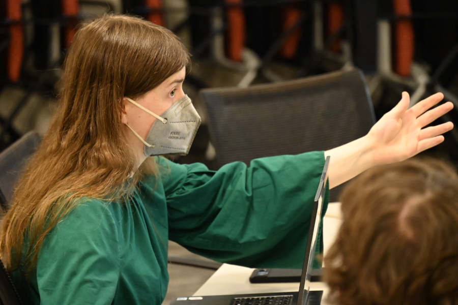 An MBAC raises her hand while talking