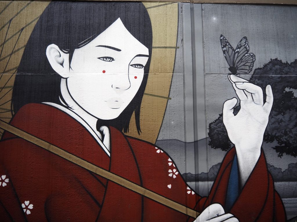 A mural of a woman in kimono holding a butterfly
