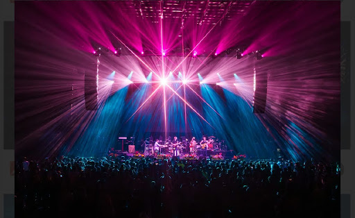 a band performing on stage with pink and blue lights