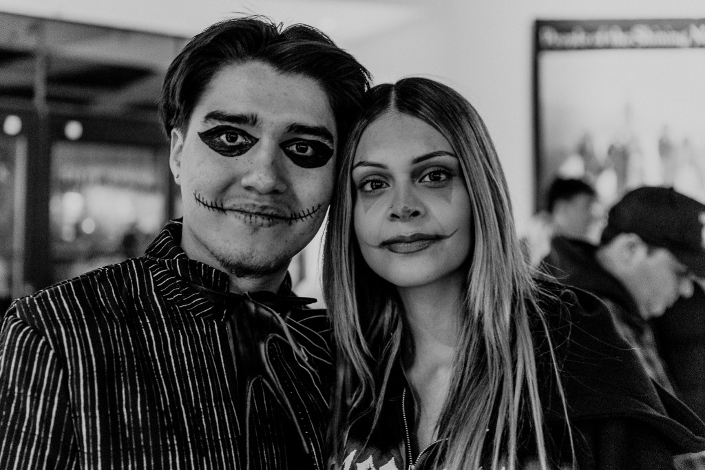A photo showing a couple dressed in a complimentary Halloween costumes.