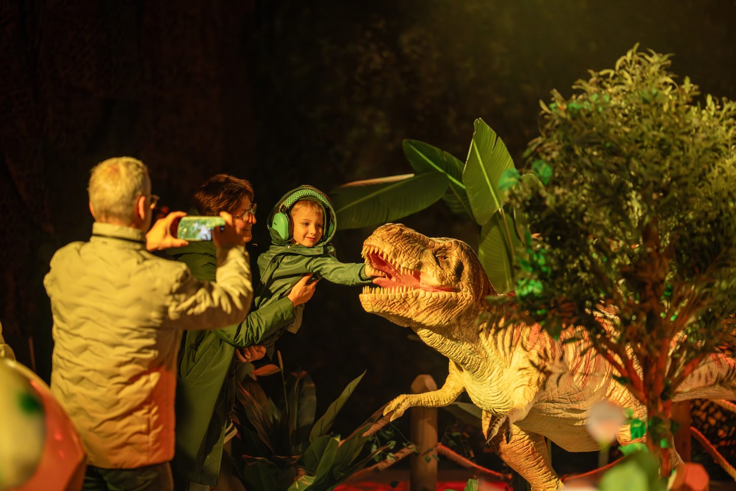 A child plays with a dinosaur animatronic.