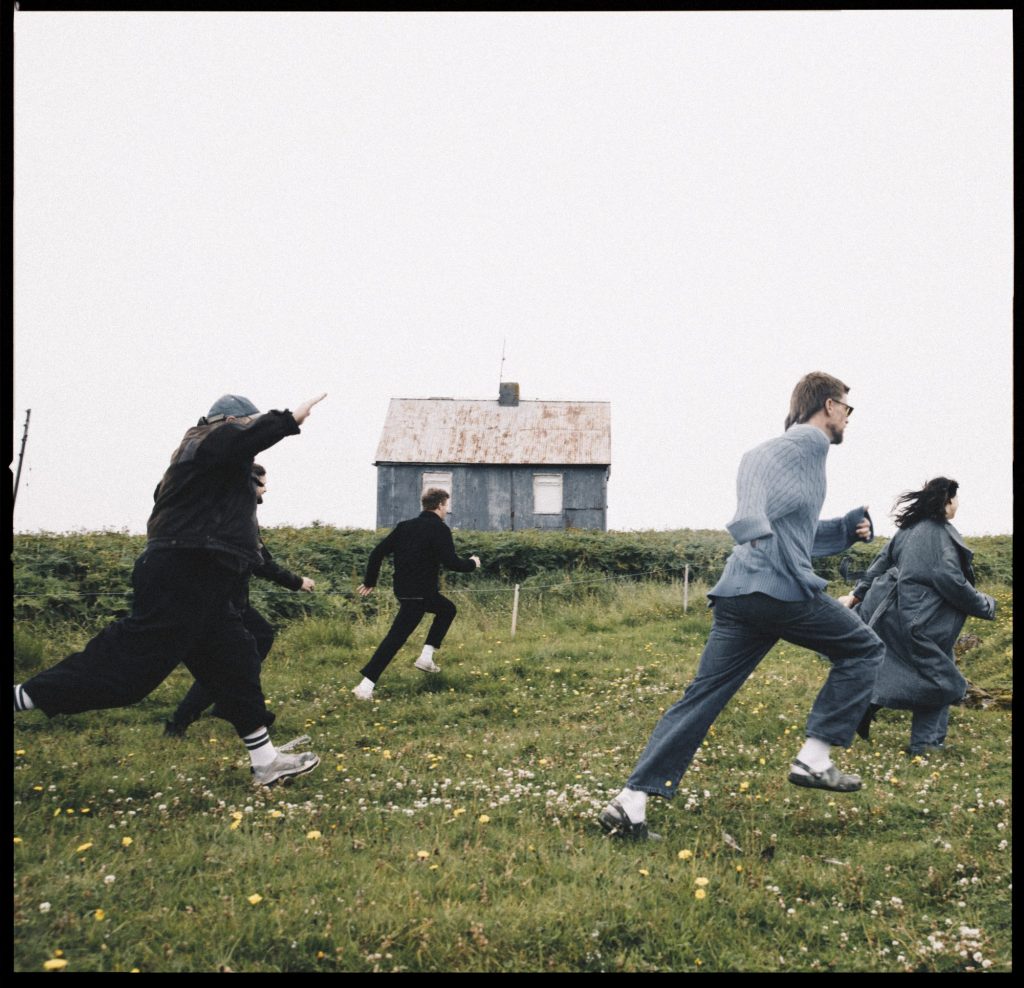 people running through a field with a barn