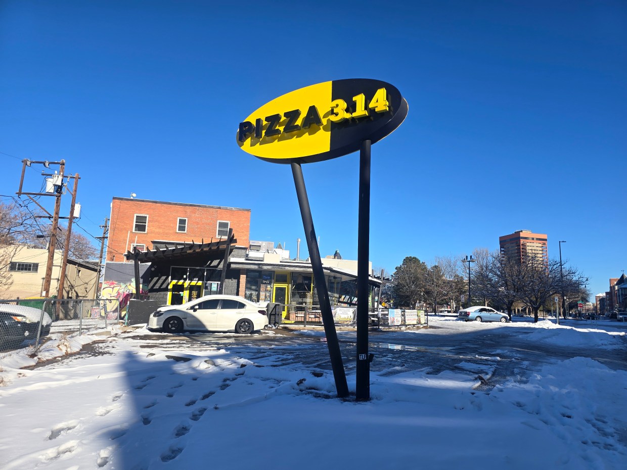 "pizza 3.14" sign in front of a building