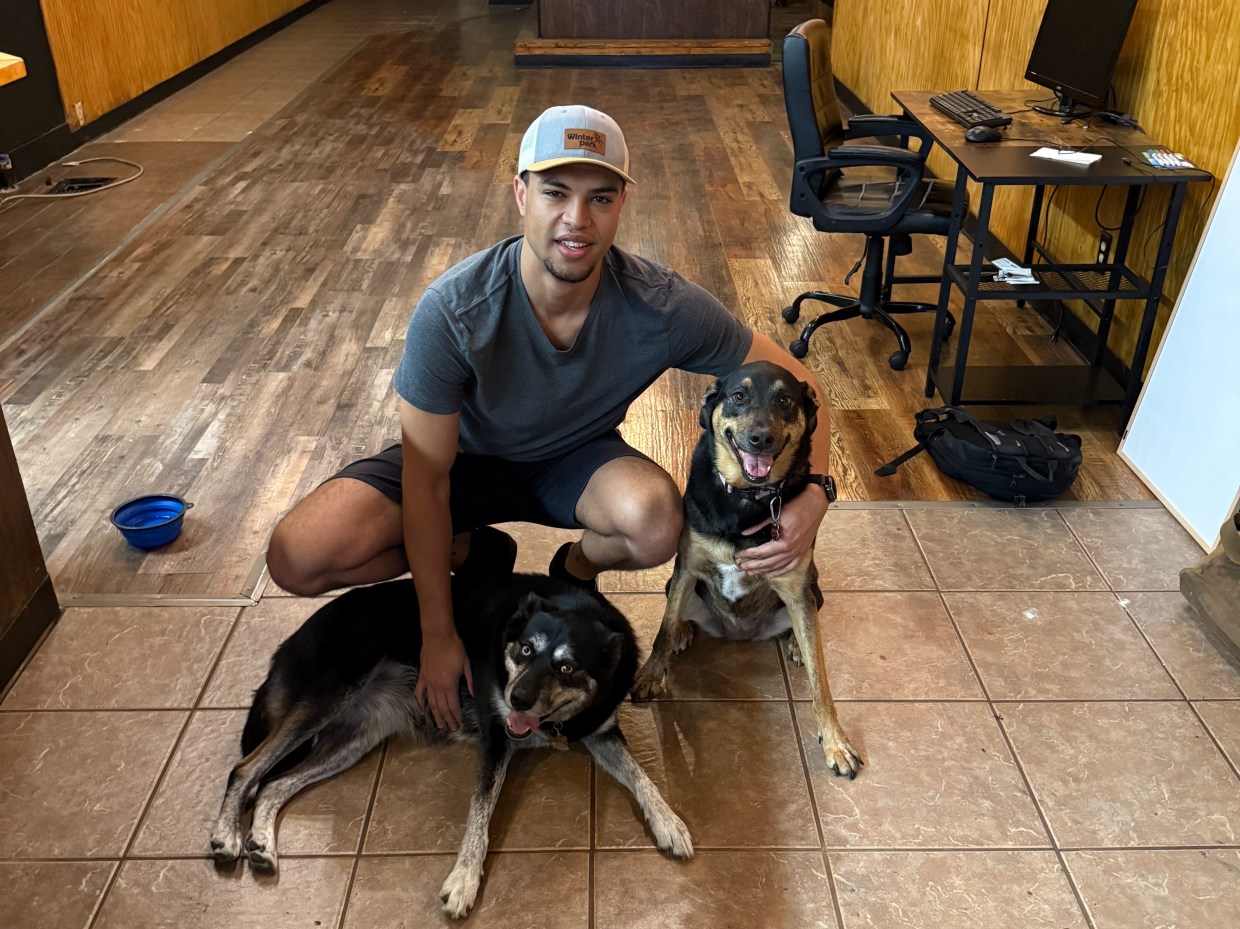 man posing with two dogs