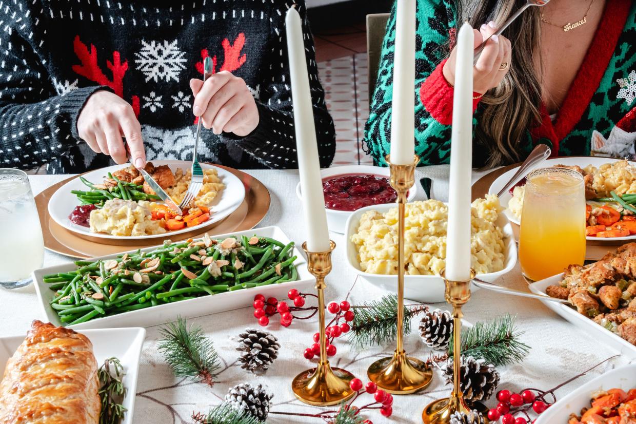 Two people dining on garlic mashed potatoes, green bean almondine and more holiday dishes from Next Level Veggie Grill