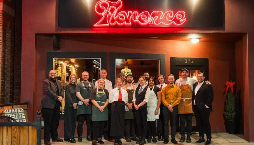 group of people posing in front of a restaurant