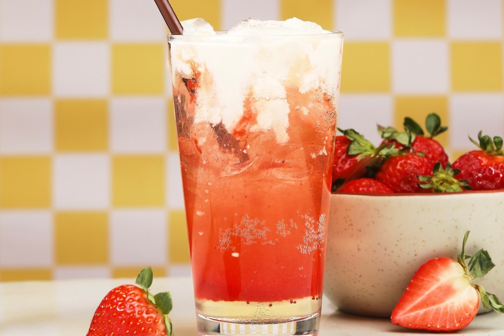 The pink-hued strawberry shortcake dirty soda from Snooze, featuring a vanilla cream topping