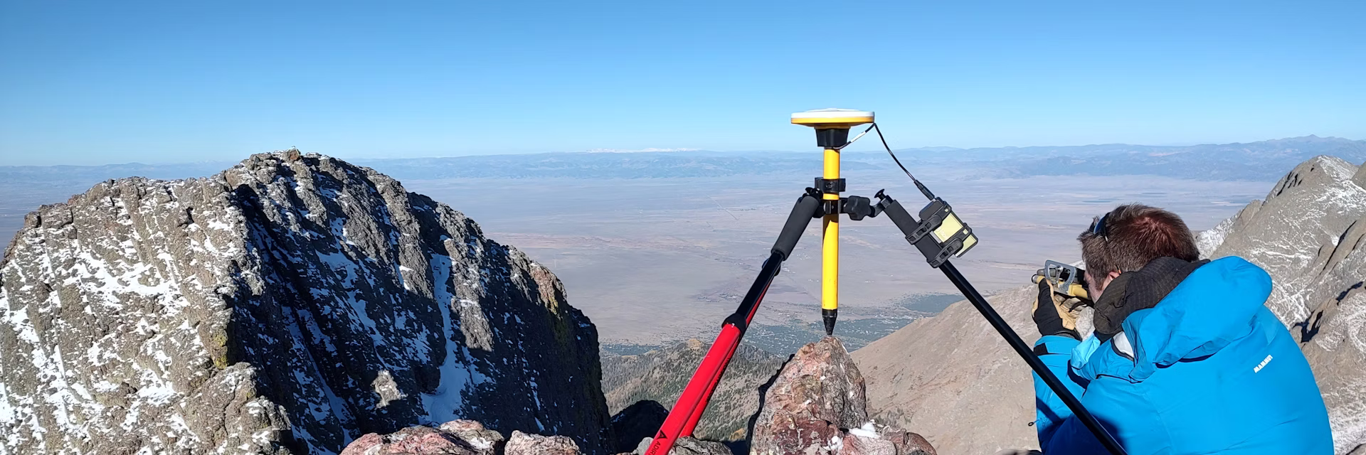 man measures distance from mountain top with GPS