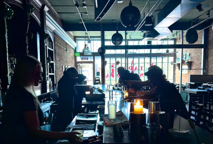 bartenders pour drink in dark bar without electricity