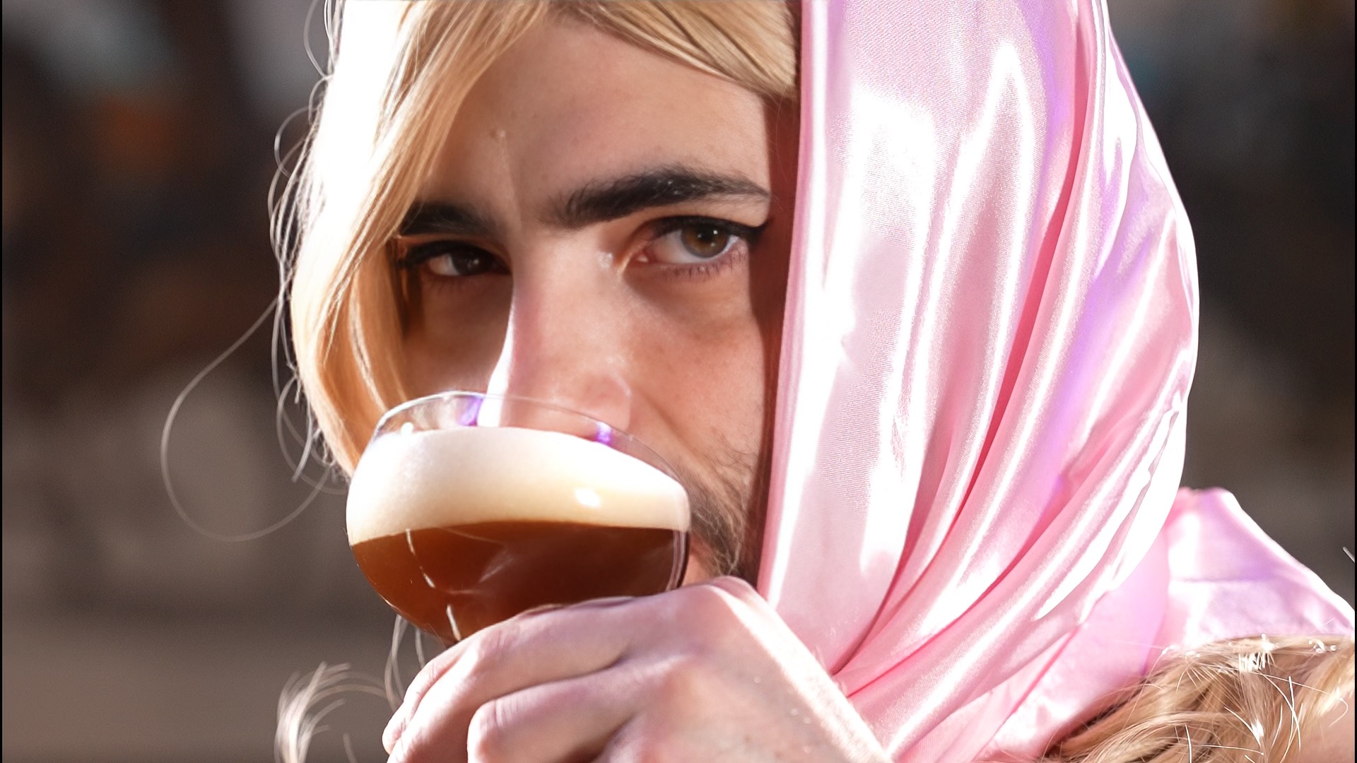 man dressed as Sabrina Carpenter, sipping espresso martini