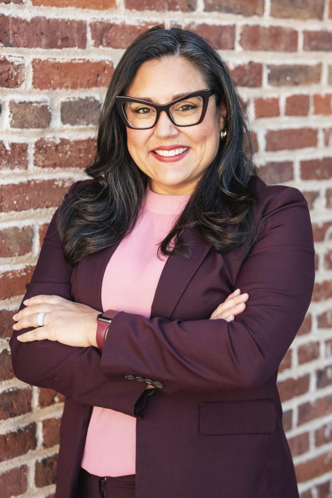 A woman standing in front of a brick wall