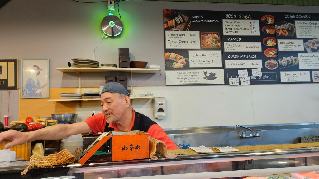 chef behind a sushi counter