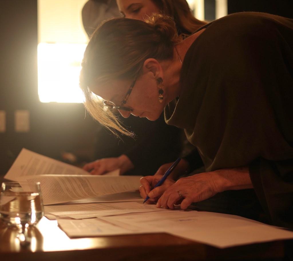 a woman signing papers