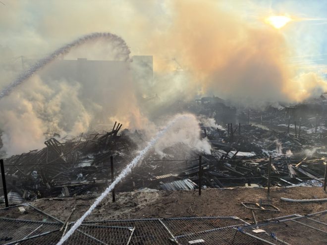 firefighters hose down construction fire