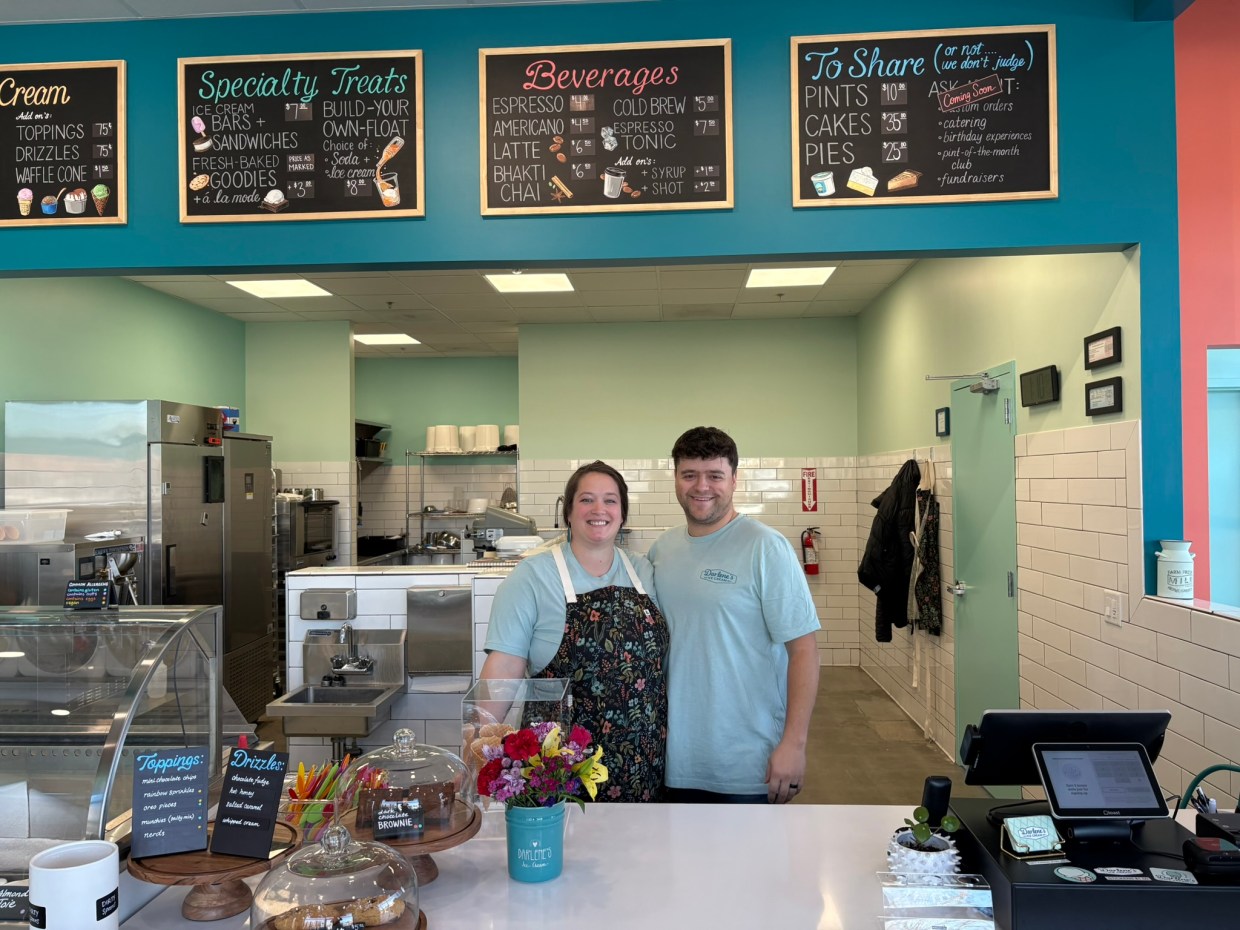 man and woman standing behind ice cream shop counter