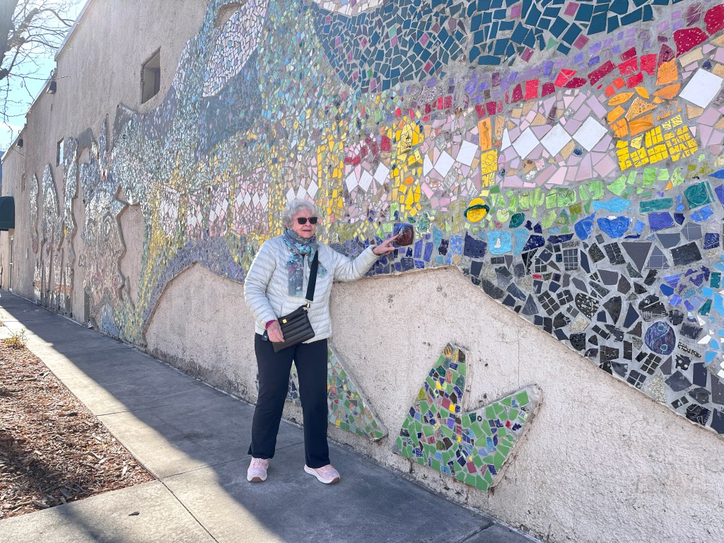 Linda points at a mural