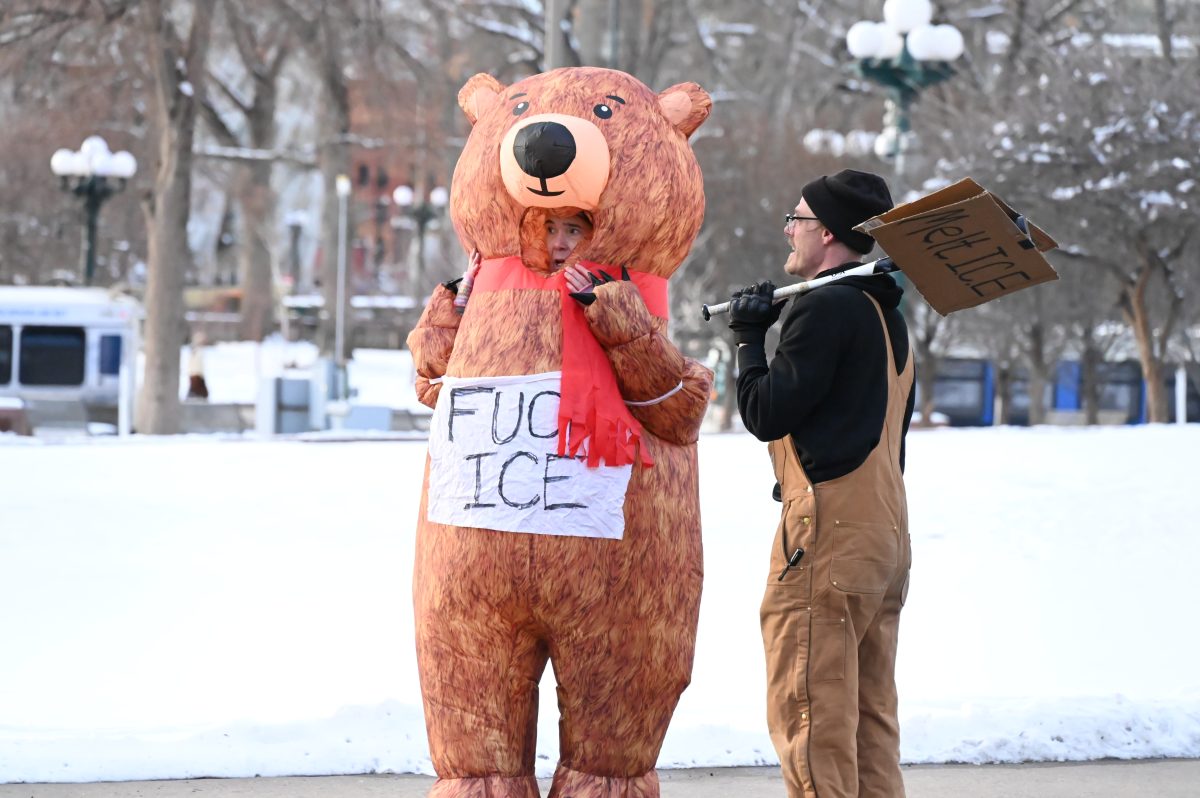 anti-ICE Protester in bear suit stands in the snow