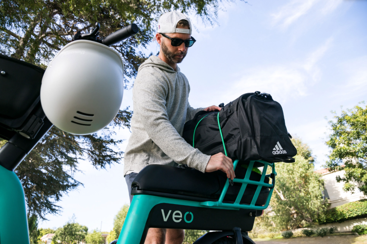 man loads up rented scooter