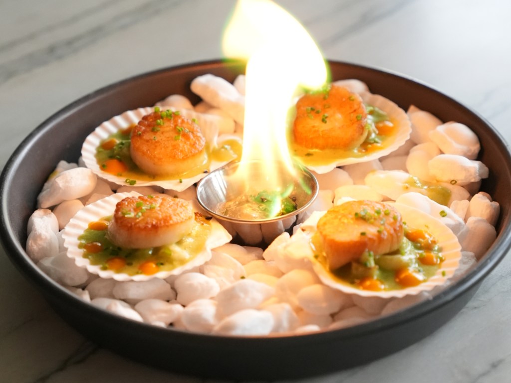 scallops on a plate with fire in the middle