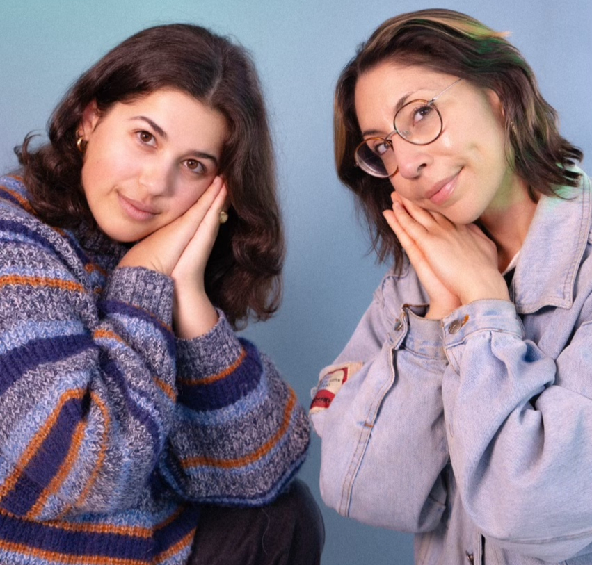 Two comedians lay their heads on their hands