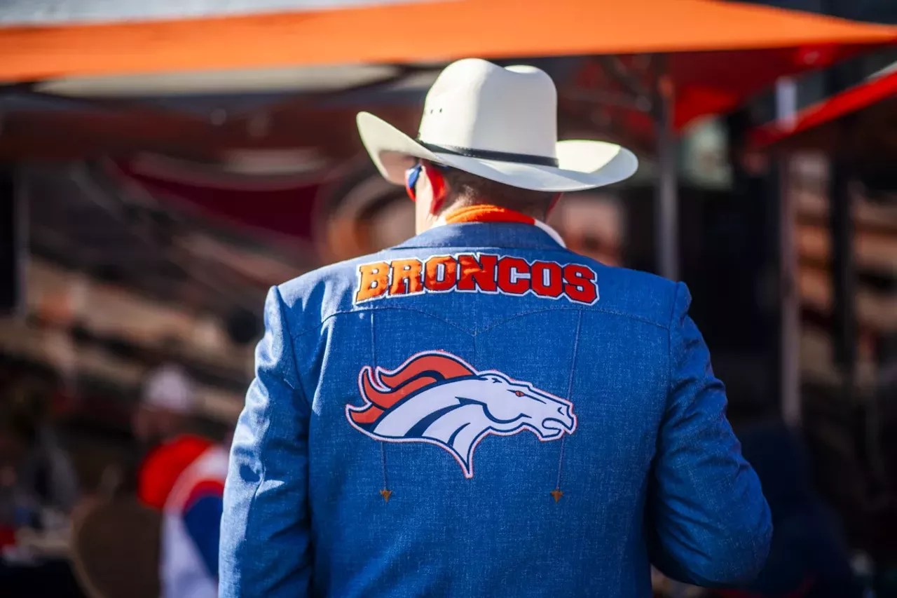 man wearing denver broncos denim jacket and cowboy hat