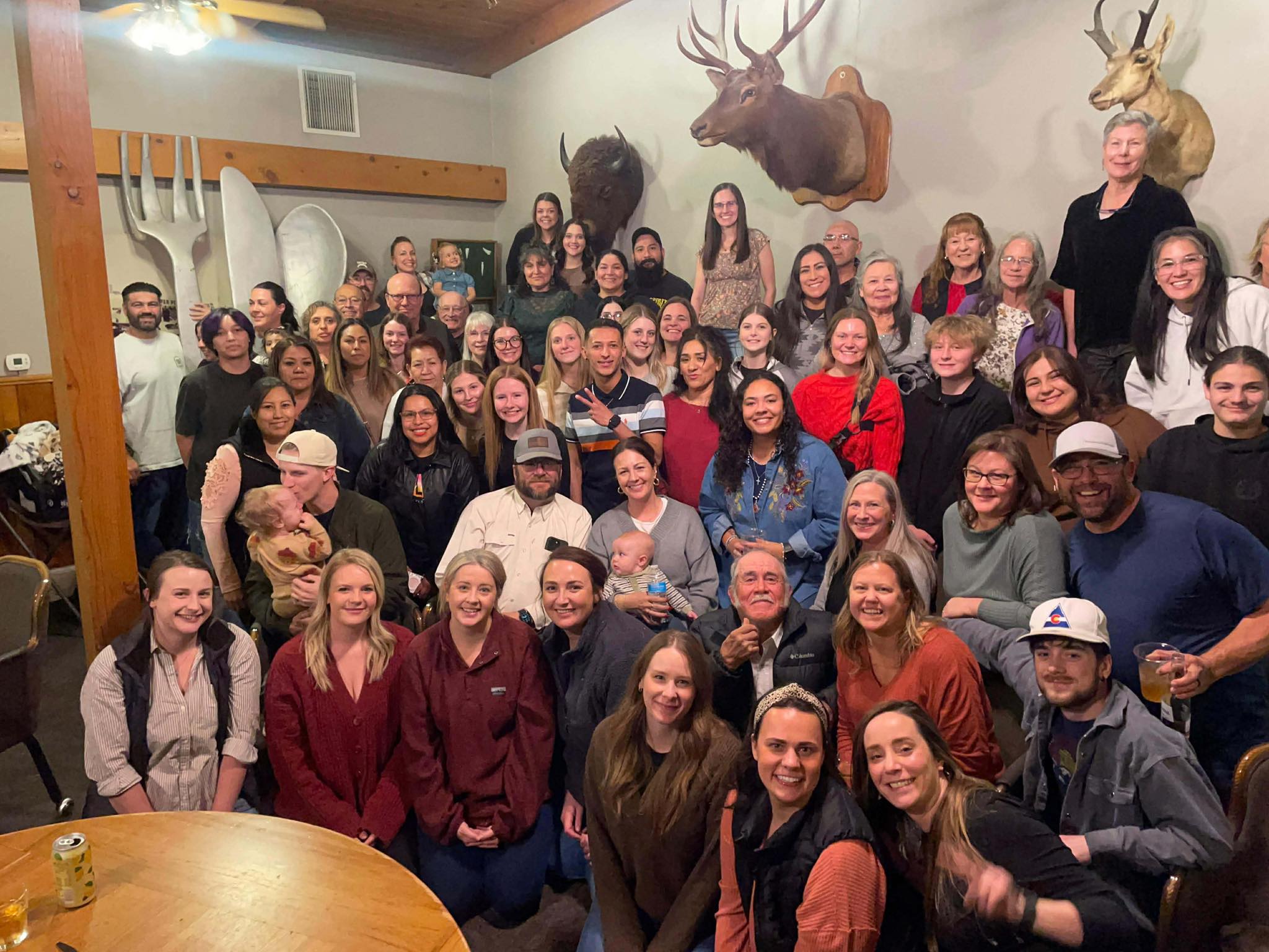 large group of people posing for a group photo in a restaurant