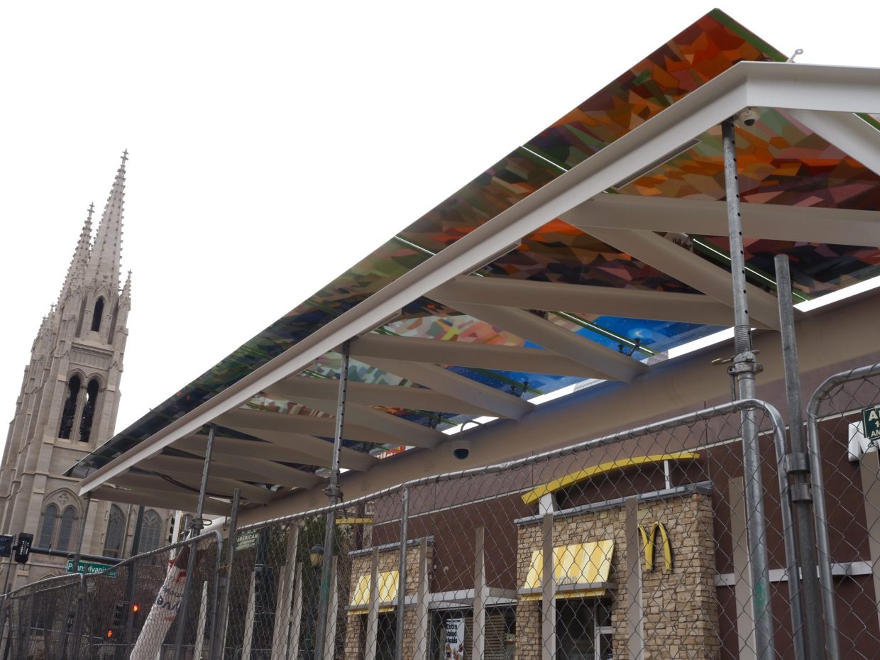 A bus station with art under its arch.