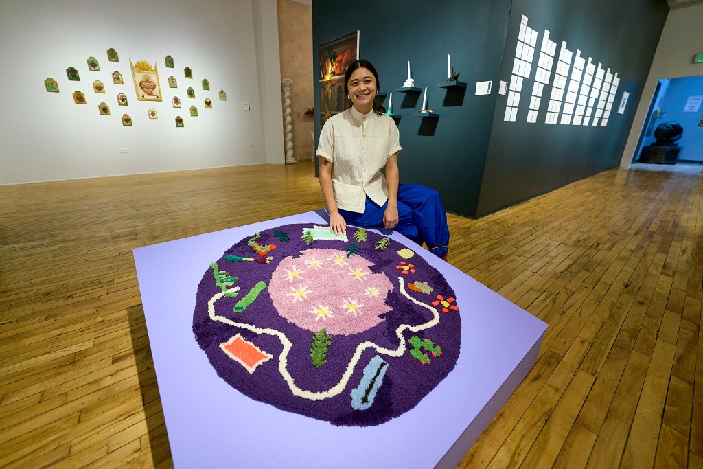 An artist sits with her work