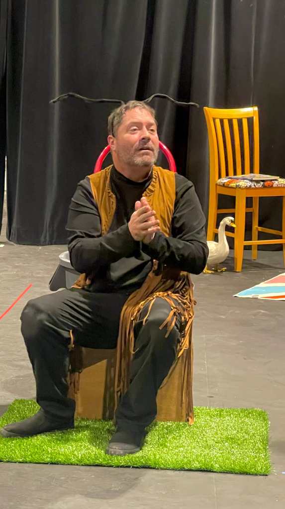 An actor sits on a block