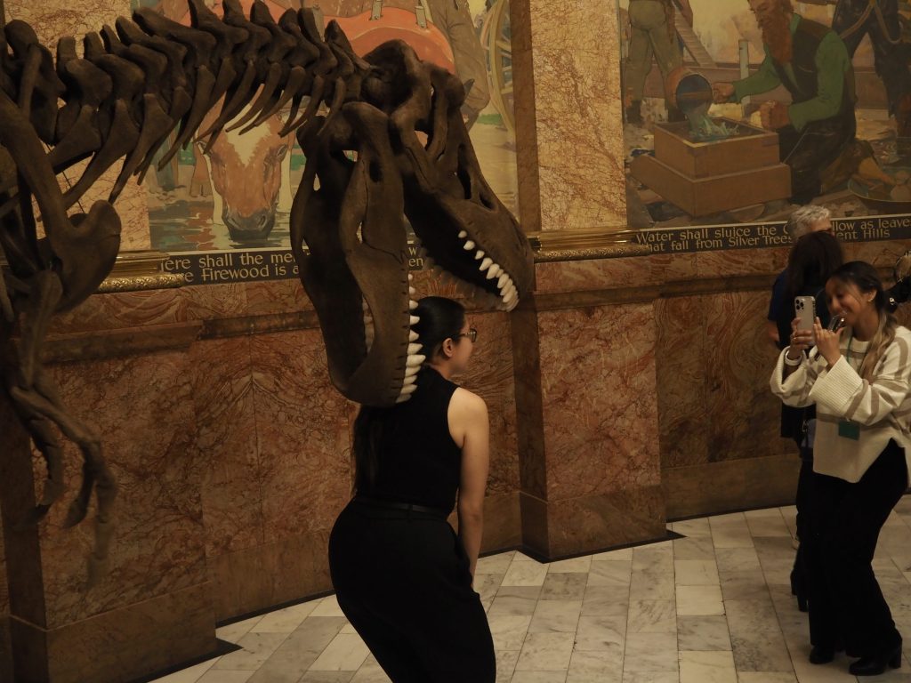 people pose with a dinosaur