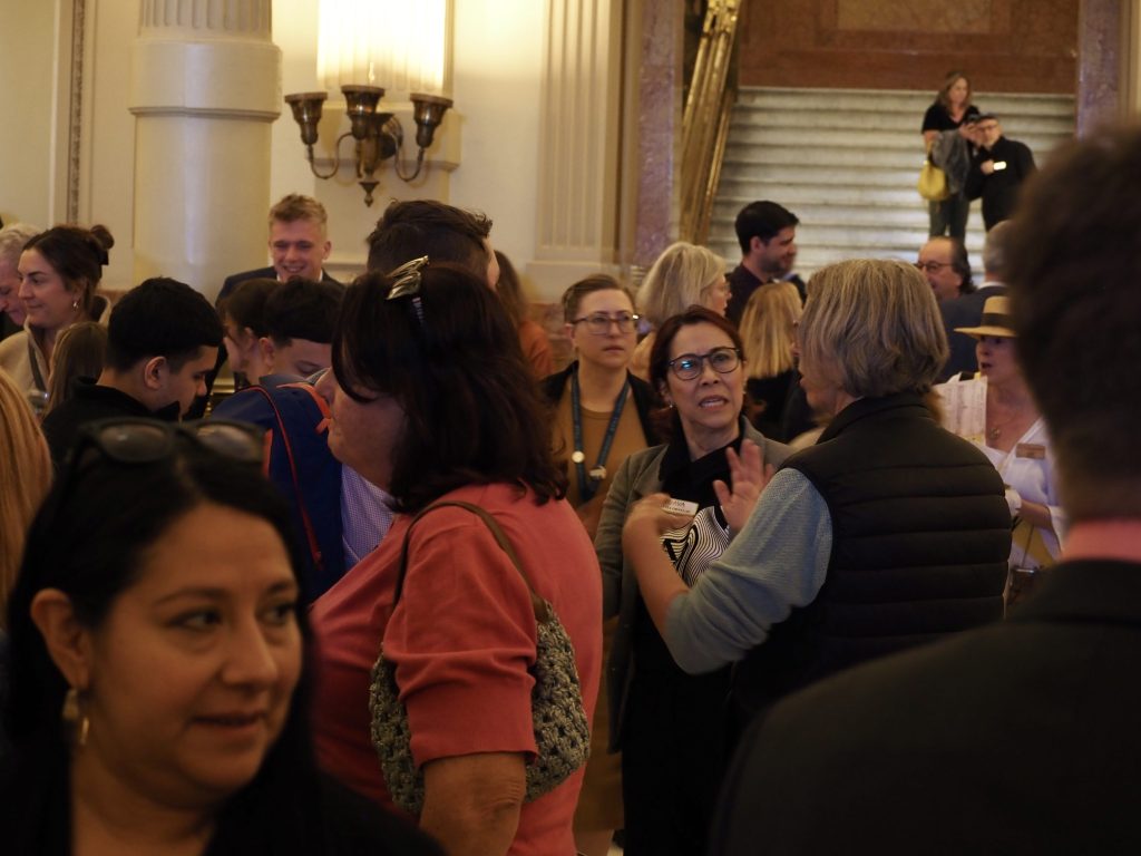 People talk to each other in a crowded room