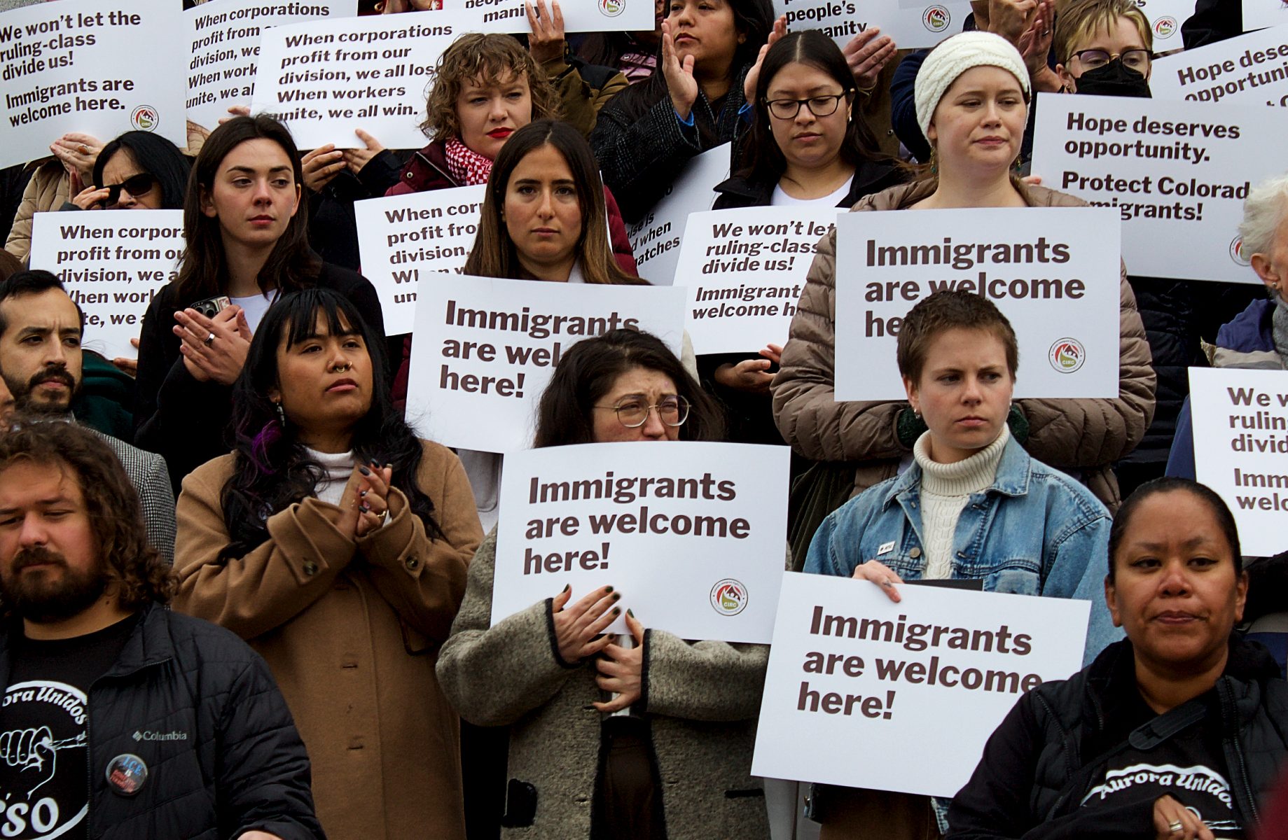 immigrant activists hold signs at colorado capitol