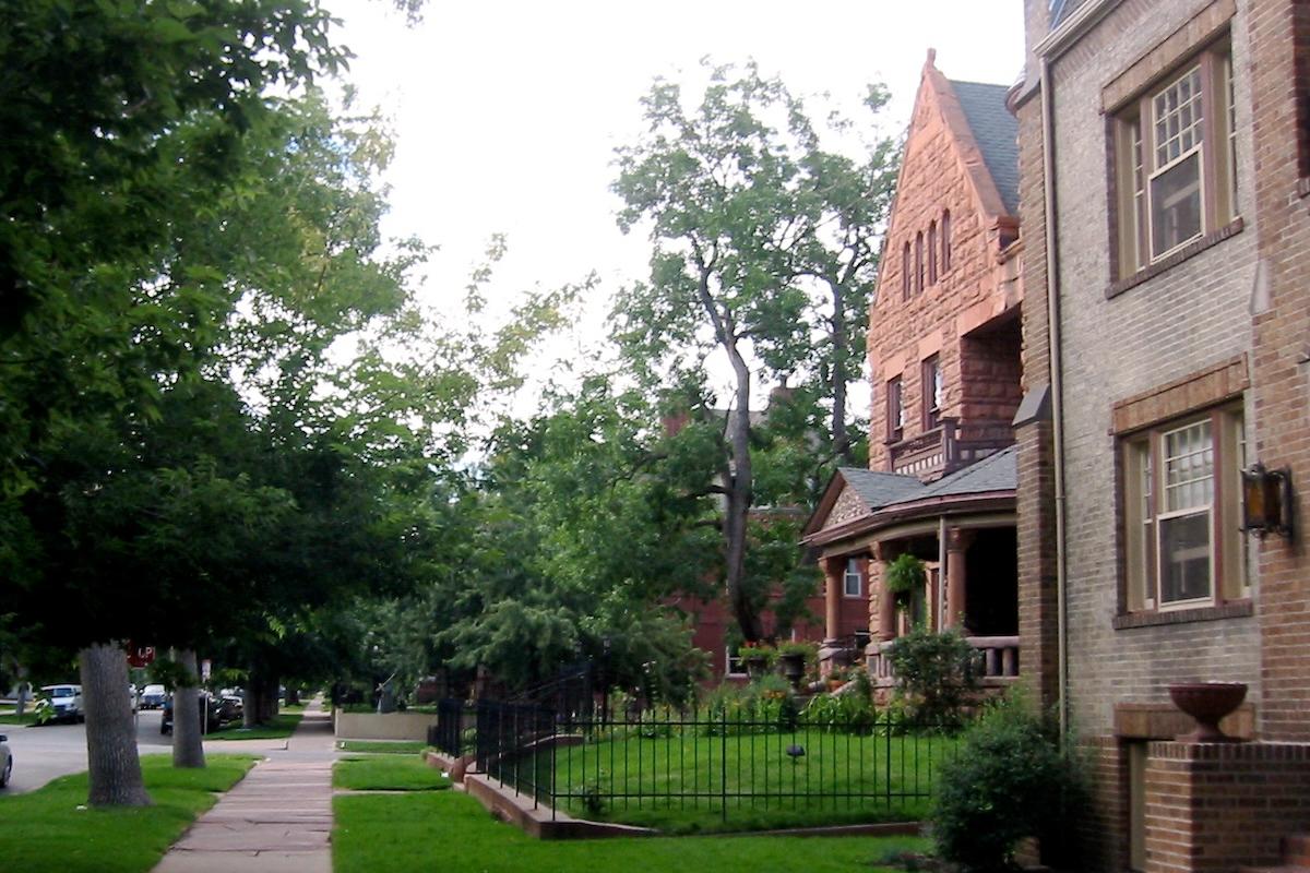 A row of old homes with lush lawns in east-central Denver