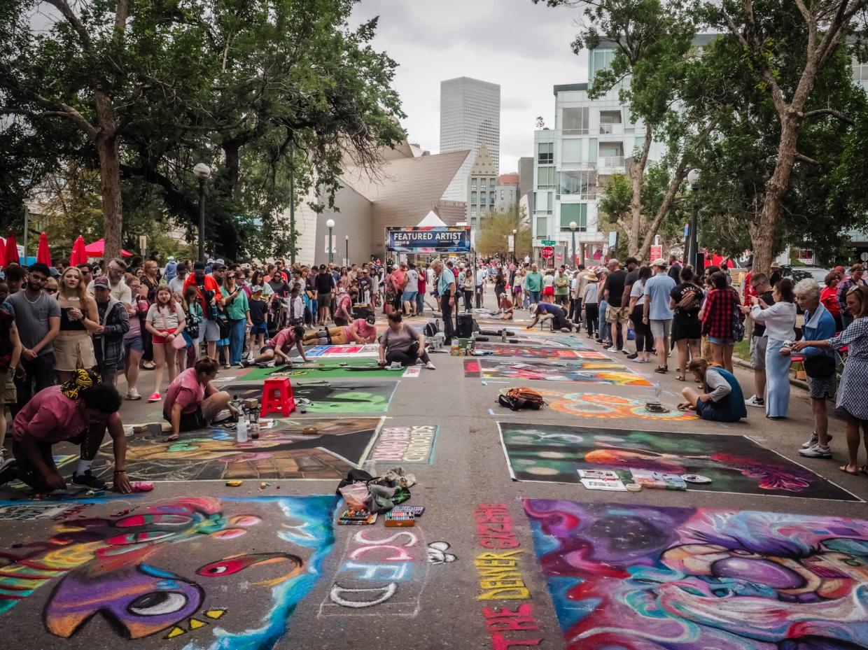 Artists working with chalk while a crowd watches