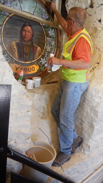 Phil Watkins working on repairs of the window depicting Chief Ouray in the Hall of Fame Rotunda.