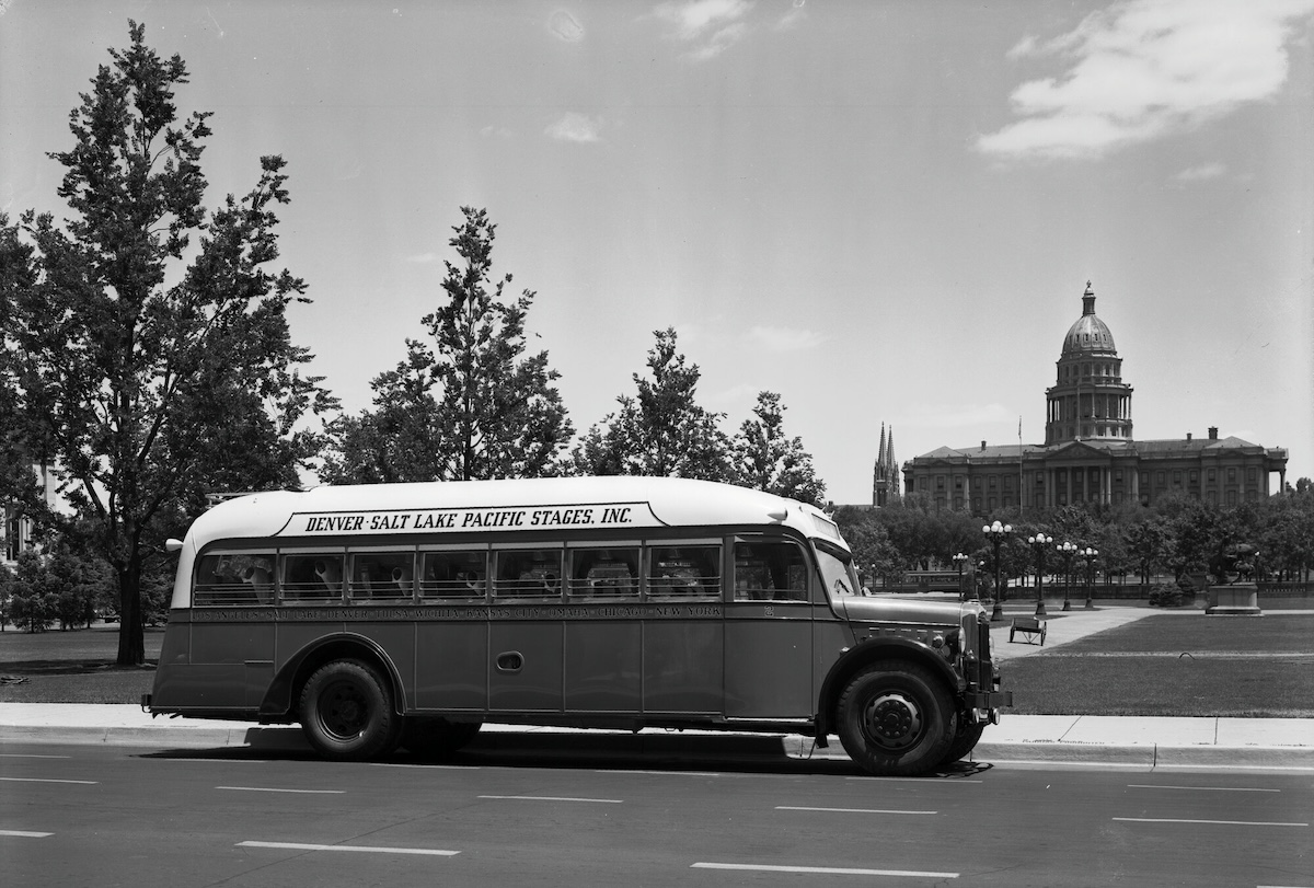 A Rio Grande Motor Way bus drives by the Colorado State Capitol in the 1920s or '30s.