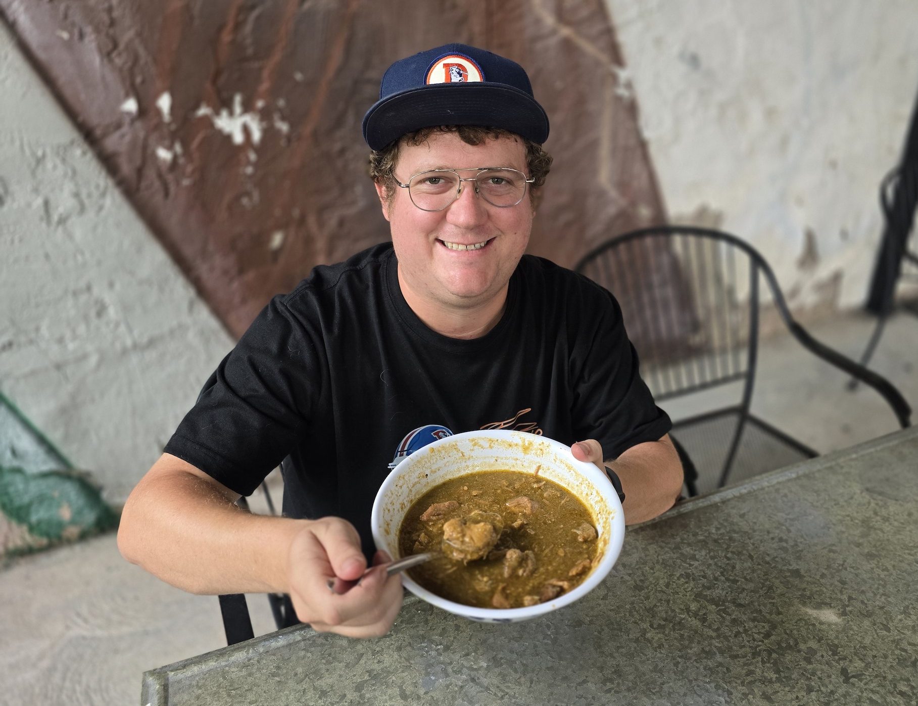 man holding bowl of green chile
