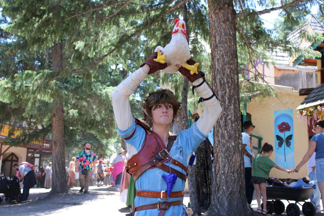 A man dressed as Link holds a chicken