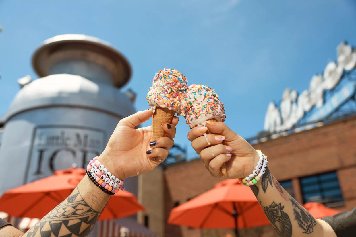 Two people holding ice cream cones in front of Little Man's milk bucket-shaped outpost