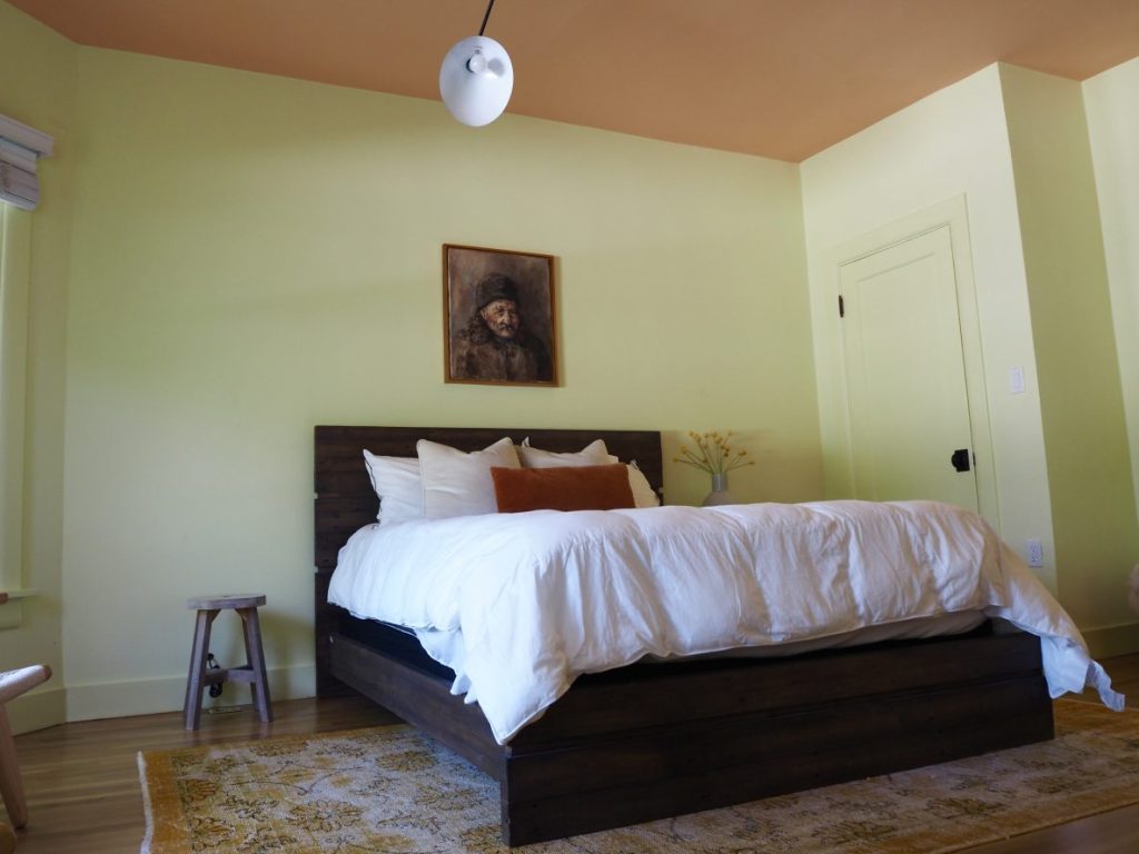 This bedroom is decorated in a pleasing green and orange.